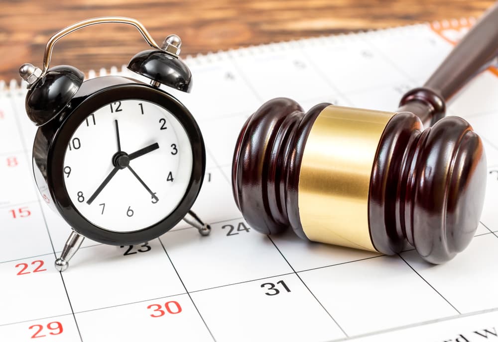 A clock and judge's gavel over the calendar