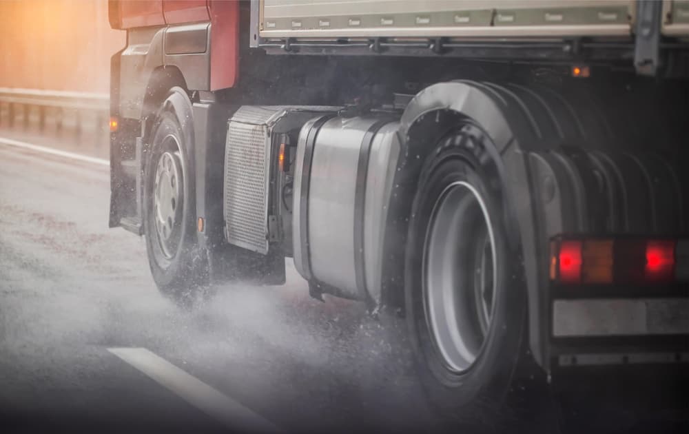 Truck chassis and wheels on a wet road in rainy weather. Safety concept and tire grip on wet roads, braking distances under emergency braking.