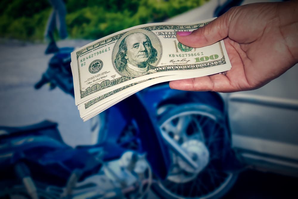 Lady giving money on account motorcycle accident injuries compensation