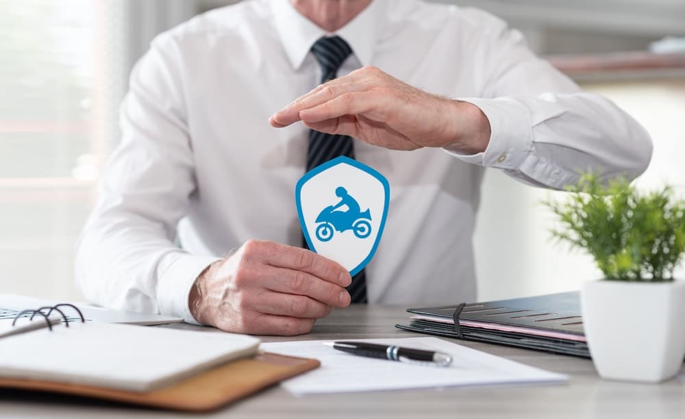 Motorcycle accident attorney holding motorbike symbol sticker in his hands