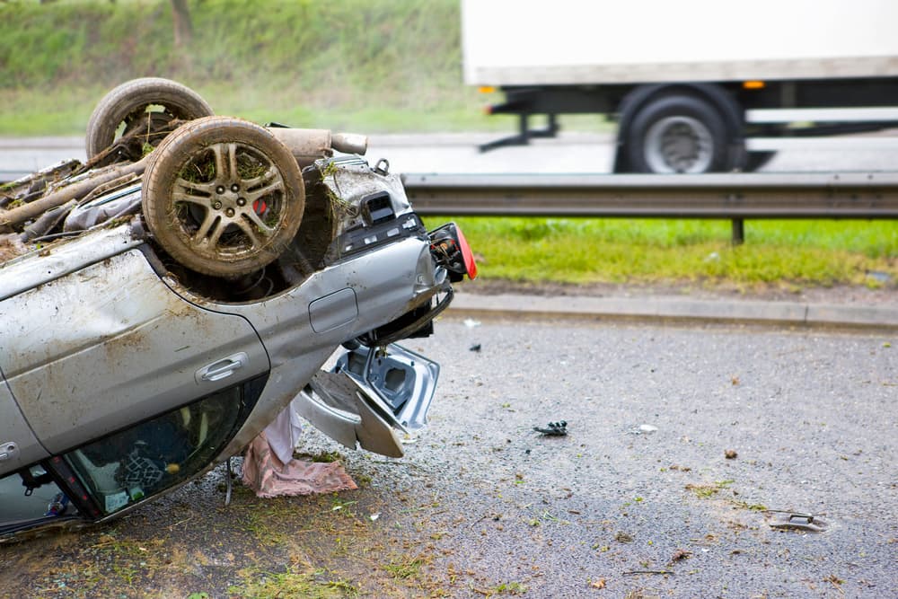 Shot of the trunk of a car lying upside down after a crash on a motorway